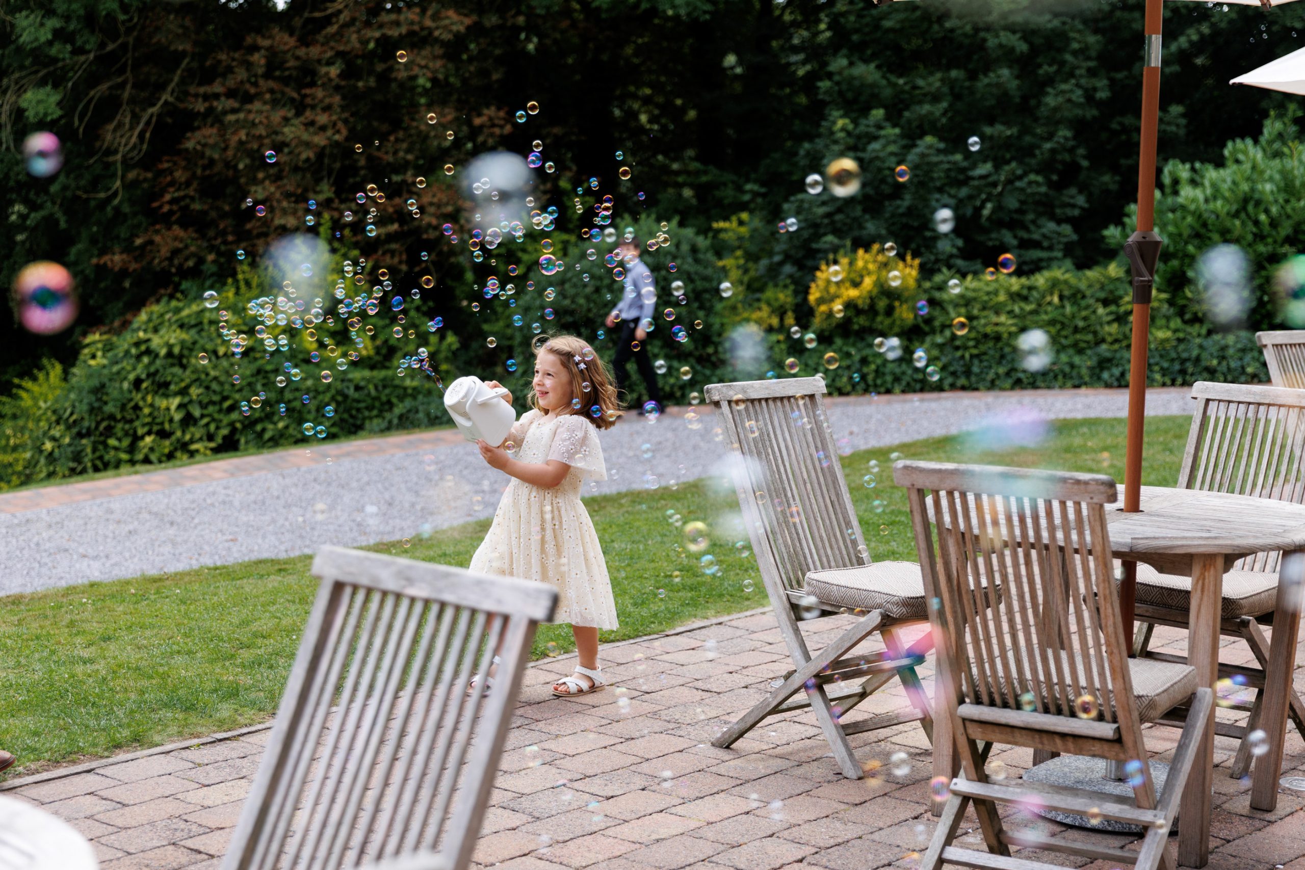 Children playing with bubble machine during family wedding at Woodlands Hotel Leeds