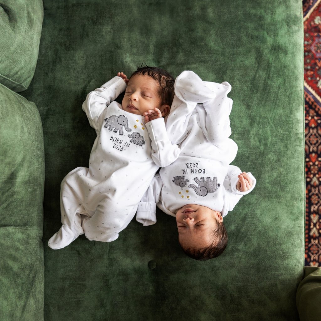 Newborn twins top and tail on green sofa, laid back newborn photography in their own home