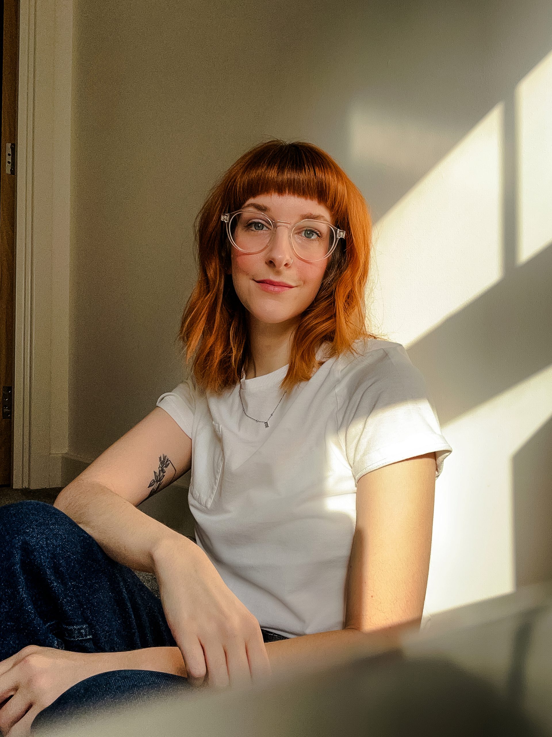 Christa Chadwick a portrait and wedding photographer from Leeds, Yorkshire. Self Portrait sitting on stairs with natural light coming through the window.